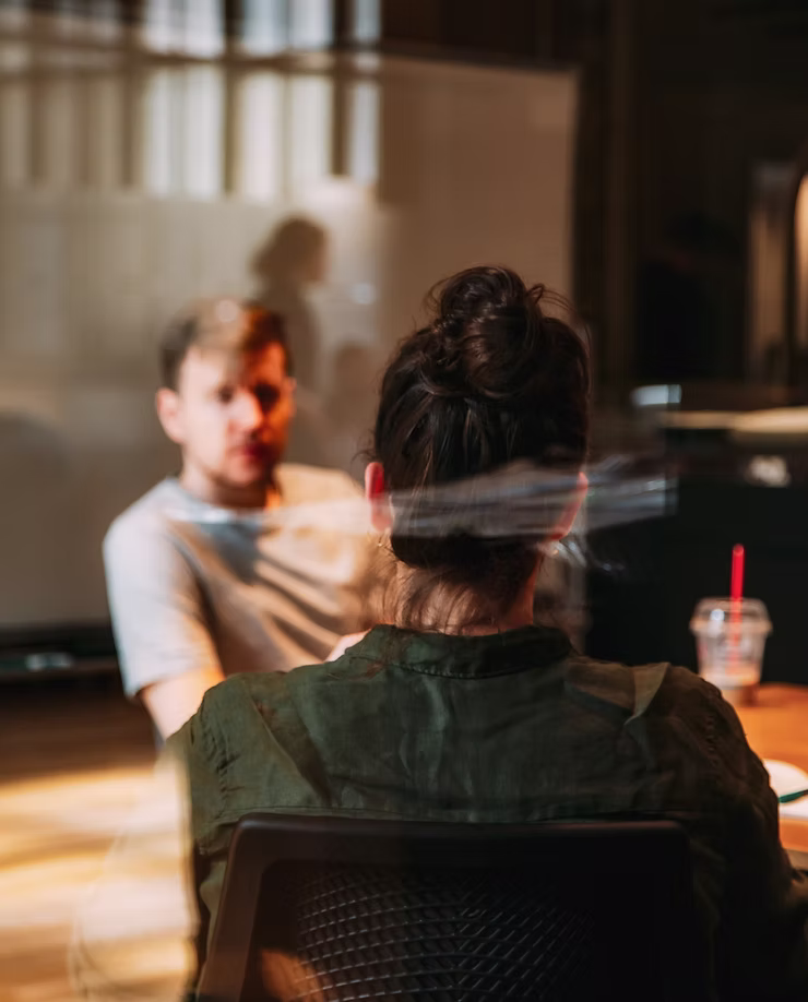 Two casually dressed people talk together.
