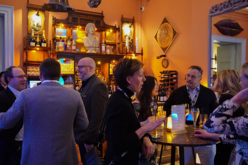 A group of C-suite professionals talk at a Blend community networking event in an upmarket bar.
